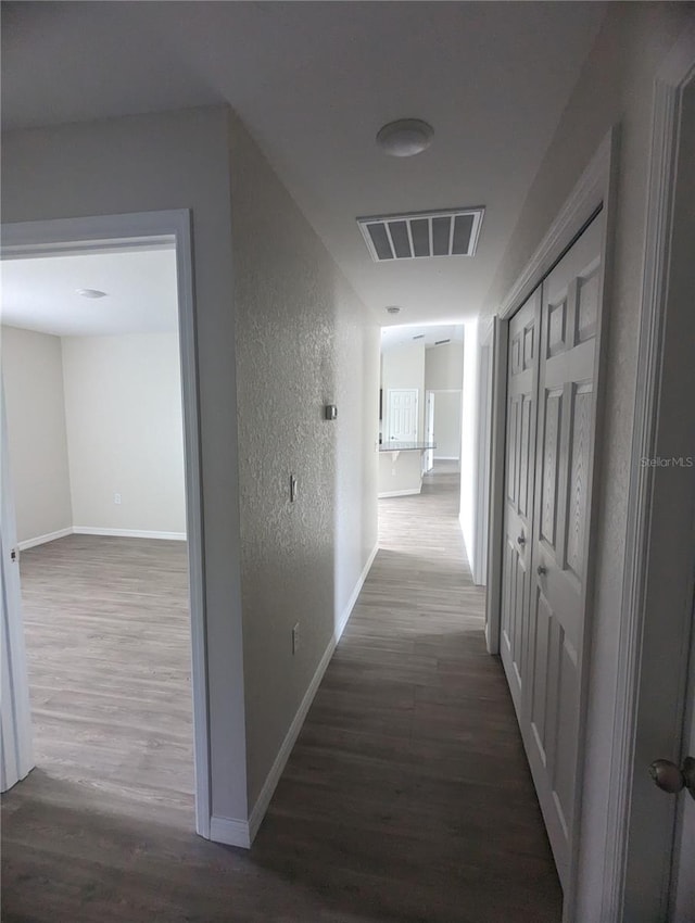 corridor with hardwood / wood-style flooring