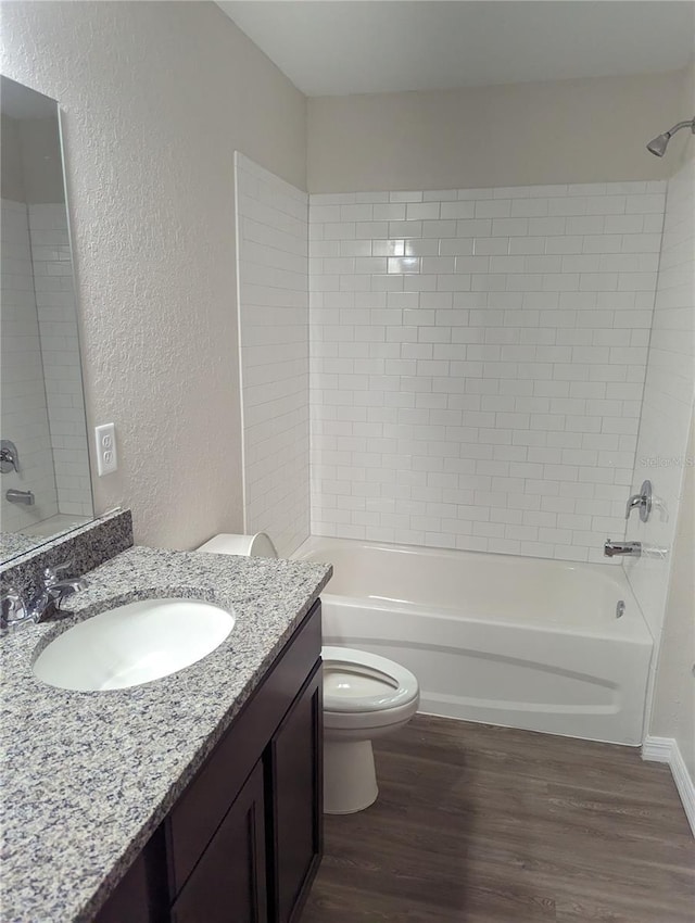 full bathroom with vanity, tiled shower / bath combo, wood-type flooring, and toilet