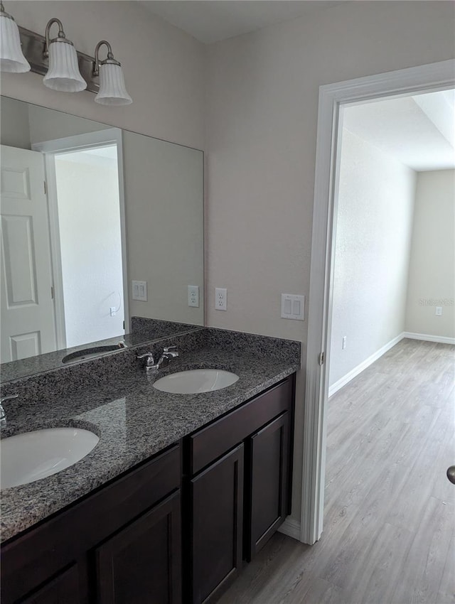2792 SW 161st Loop, Ocala, FL 34473 - bathroom featuring wood finished floors, double vanity, and baseboards