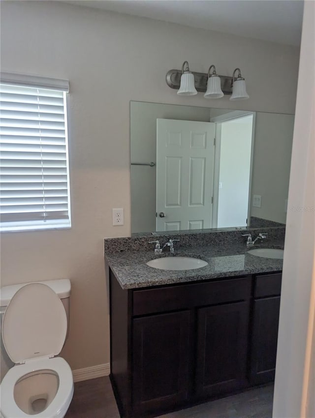 2792 SW 161st Loop, Ocala, FL 34473 - bathroom featuring double vanity, toilet, baseboards, and wood finished floors