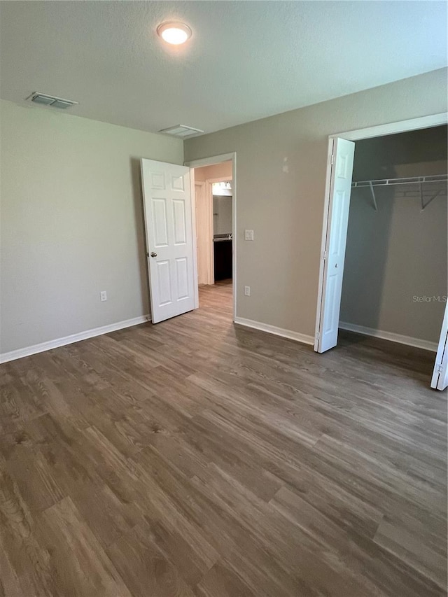 2792 SW 161st Loop, Ocala, FL 34473 - unfurnished bedroom with dark wood-style floors, baseboards, and a closet
