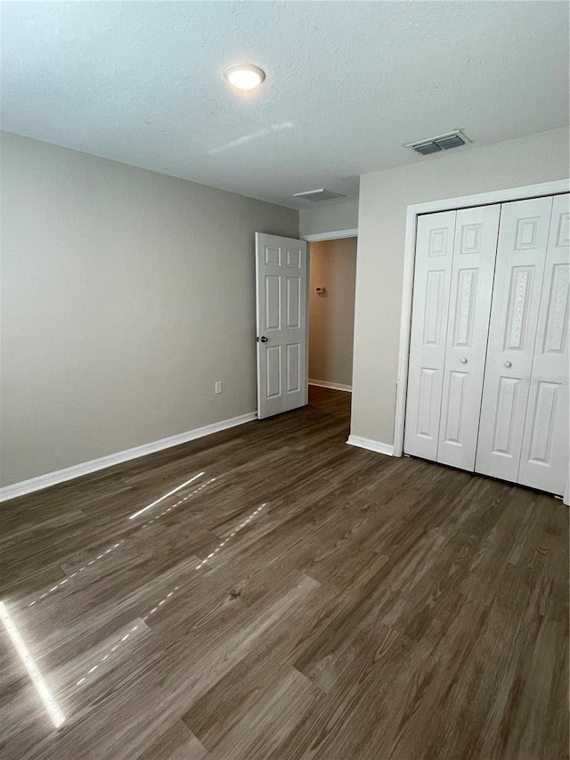 2792 SW 161st Loop, Ocala, FL 34473 - unfurnished bedroom with baseboards, dark wood-style floors, and a closet