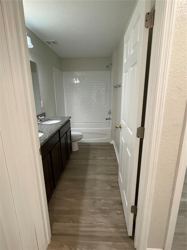 2792 SW 161st Loop, Ocala, FL 34473 - bathroom featuring toilet, vanity, wood finished floors, bathing tub / shower combination, and a textured wall