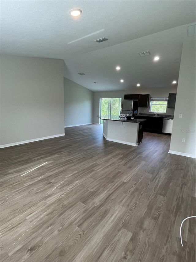 2792 SW 161st Loop, Ocala, FL 34473 - unfurnished living room with dark wood-style flooring, baseboards, healthy amount of natural light, vaulted ceiling, and recessed lighting