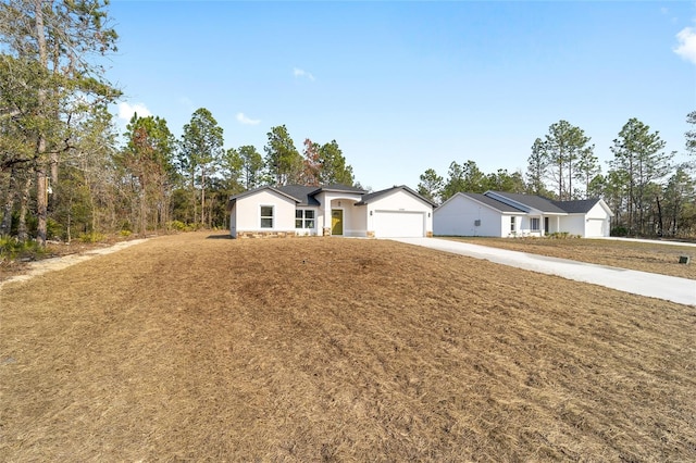 ranch-style house with a garage and a front lawn