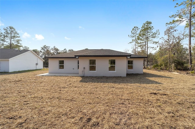 rear view of house featuring a yard and a patio area