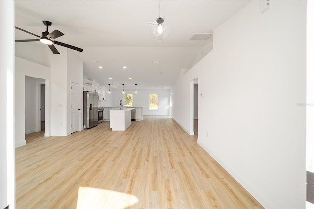 unfurnished living room featuring lofted ceiling, sink, light hardwood / wood-style floors, and ceiling fan