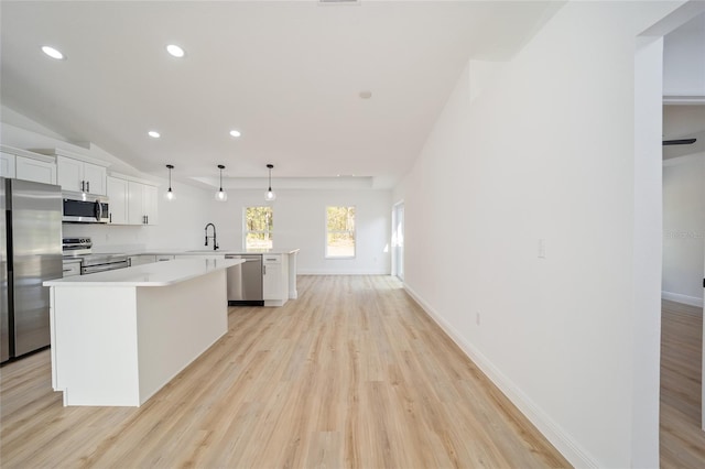 kitchen featuring stainless steel appliances, white cabinetry, pendant lighting, and kitchen peninsula