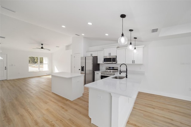 kitchen with pendant lighting, sink, white cabinets, kitchen peninsula, and stainless steel appliances