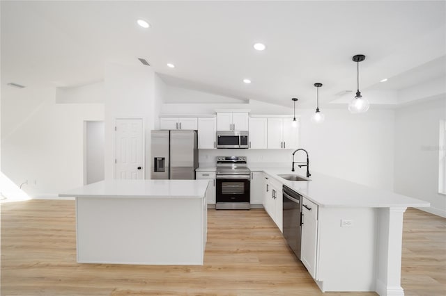 kitchen with stainless steel appliances, sink, a kitchen island, and white cabinets