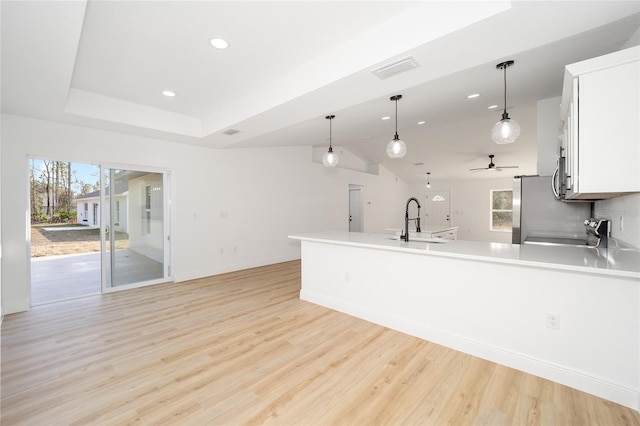 kitchen featuring white cabinetry, sink, decorative light fixtures, and appliances with stainless steel finishes