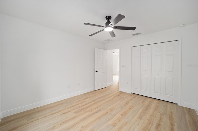 unfurnished bedroom featuring light hardwood / wood-style floors, a closet, and ceiling fan