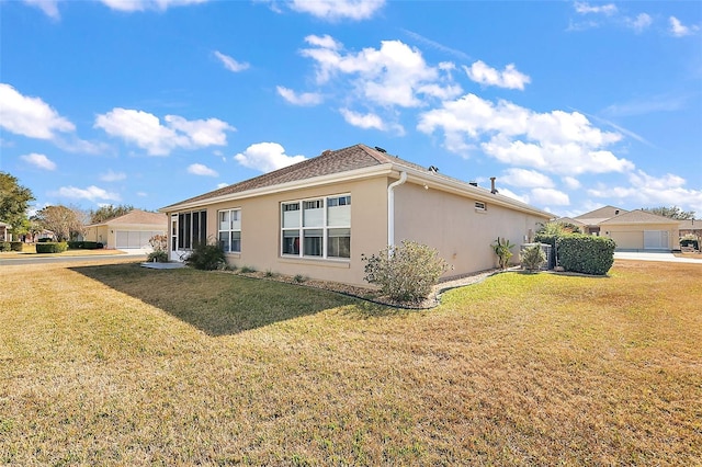 view of side of home with a garage and a lawn