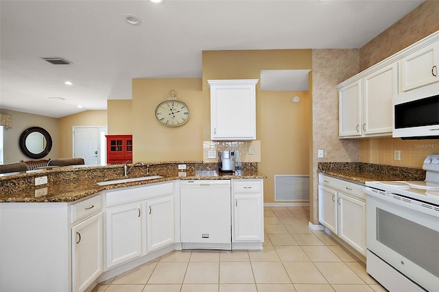 kitchen with white appliances, dark stone countertops, sink, and white cabinets