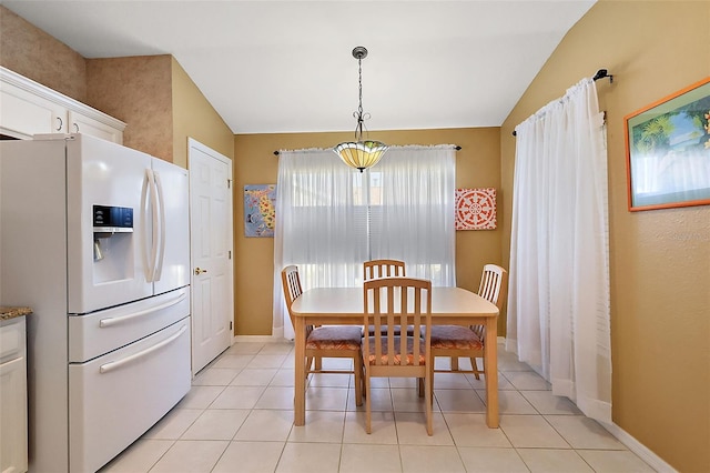 dining area featuring vaulted ceiling and light tile patterned flooring