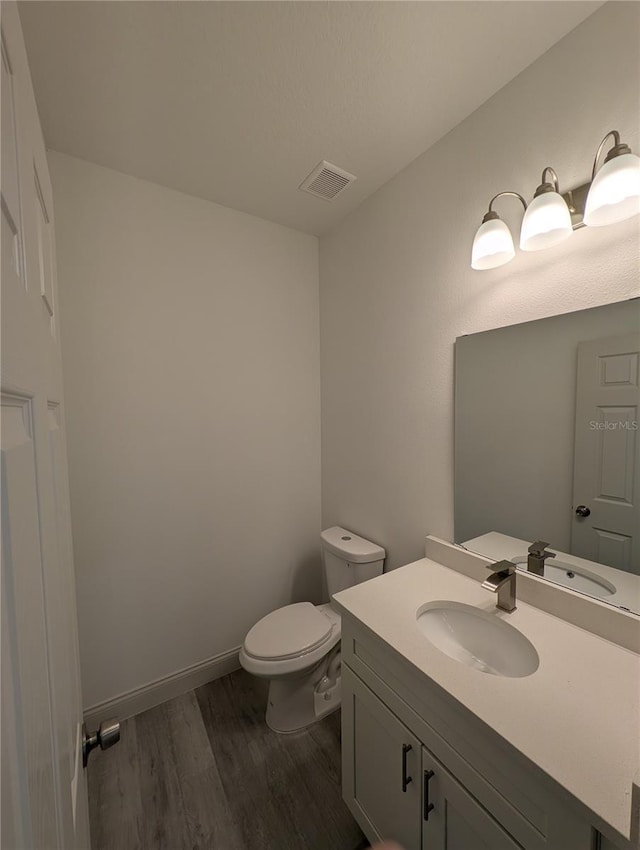 bathroom featuring hardwood / wood-style flooring, vanity, and toilet