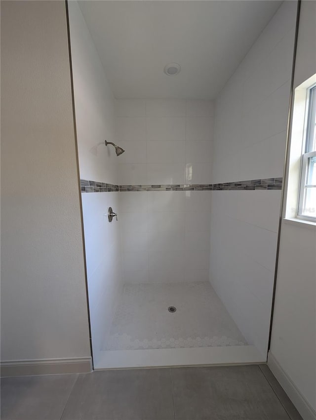 bathroom featuring a tile shower and tile patterned flooring