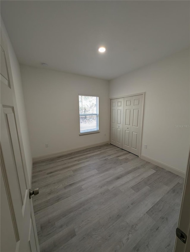 unfurnished bedroom featuring a closet and light hardwood / wood-style flooring