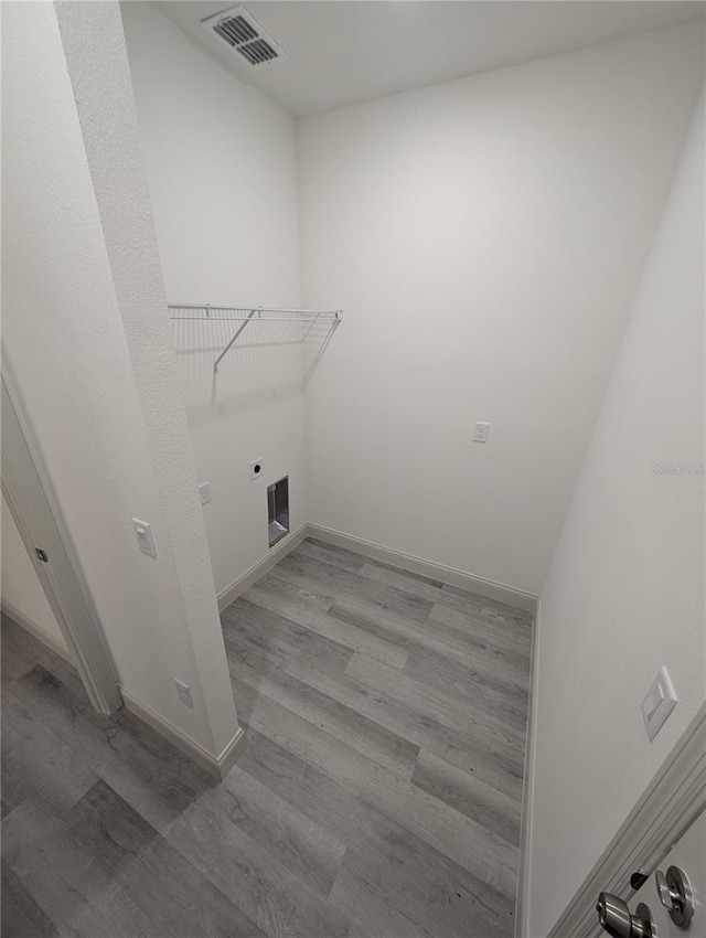 laundry area with hookup for an electric dryer and light wood-type flooring