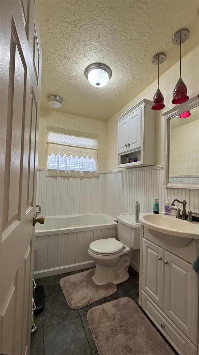 bathroom with vanity, tile patterned floors, a textured ceiling, and toilet