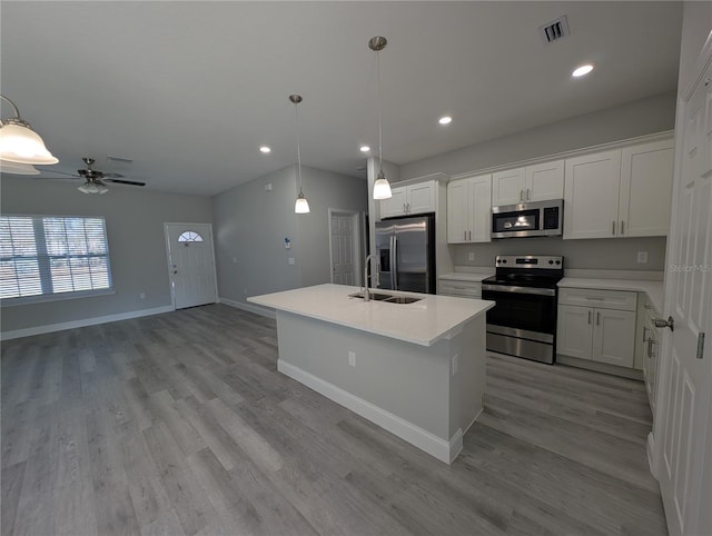 kitchen with white cabinetry, appliances with stainless steel finishes, and hanging light fixtures