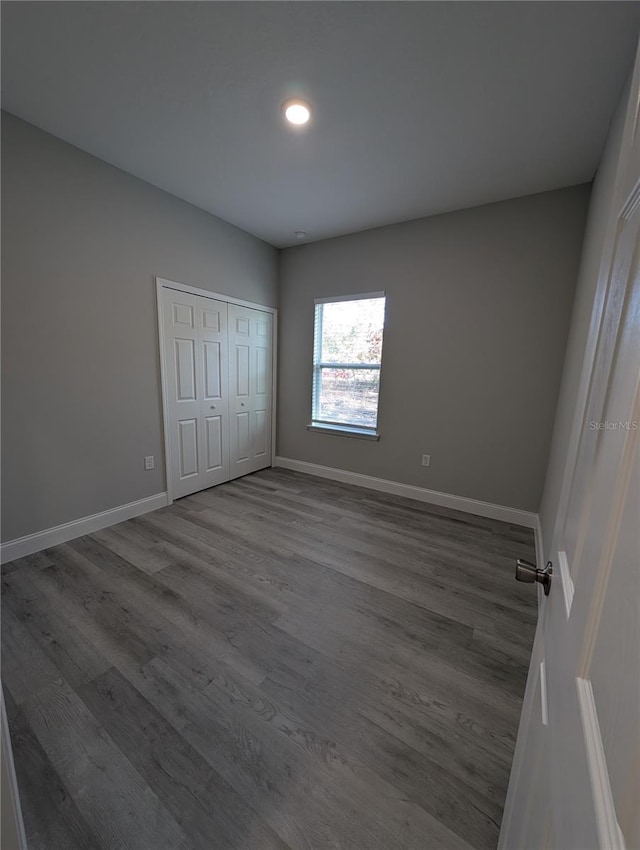 unfurnished bedroom with hardwood / wood-style flooring and a closet