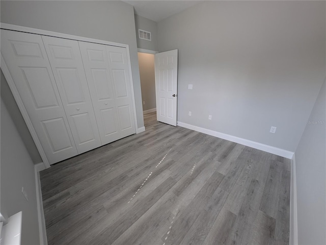 unfurnished bedroom featuring light hardwood / wood-style floors and a closet