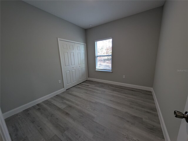 unfurnished bedroom with light hardwood / wood-style floors and a closet