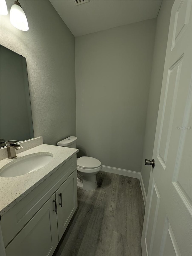 bathroom featuring vanity, hardwood / wood-style floors, and toilet