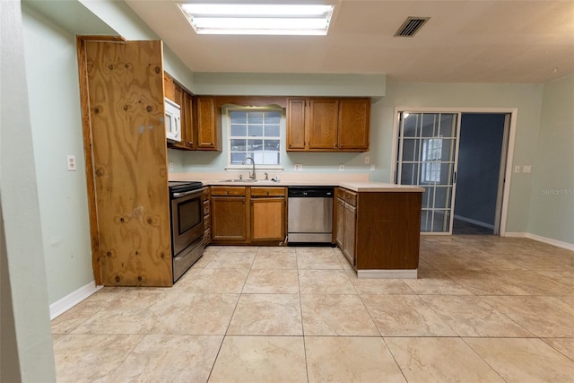 kitchen featuring stainless steel appliances, sink, and light tile patterned floors