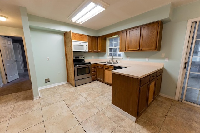 kitchen featuring electric stove, kitchen peninsula, sink, and light tile patterned floors