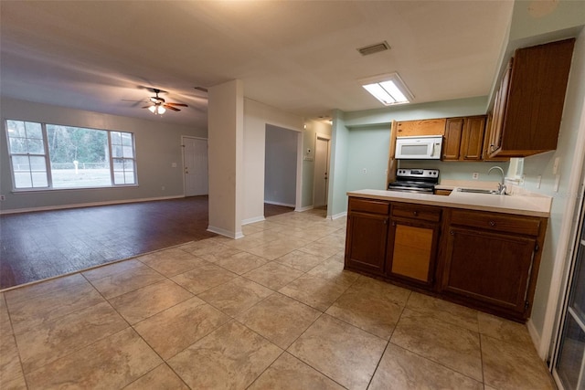 kitchen with electric stove, ceiling fan, sink, and light tile patterned floors