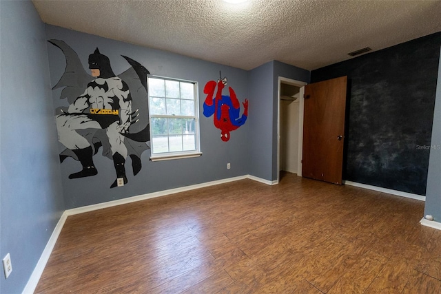 unfurnished bedroom featuring wood-type flooring and a textured ceiling