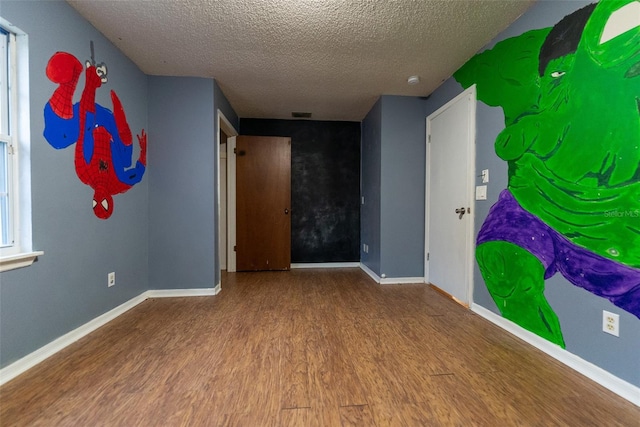 empty room featuring hardwood / wood-style flooring and a textured ceiling