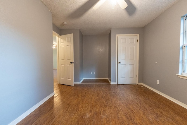 unfurnished bedroom with ceiling fan, a textured ceiling, and dark hardwood / wood-style flooring