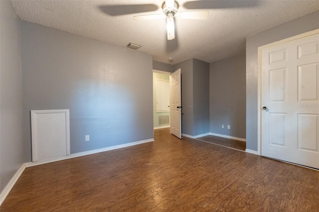 unfurnished bedroom with ceiling fan, dark wood-type flooring, and a textured ceiling