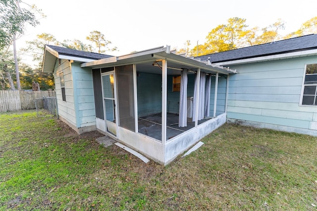 view of side of home with a lawn and a sunroom