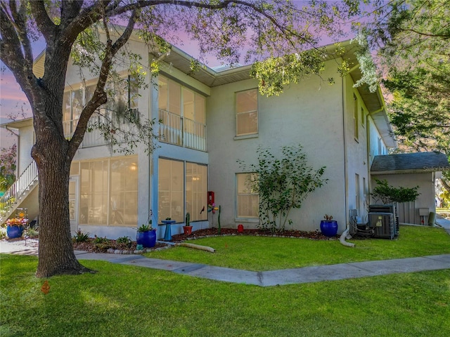 view of front of property featuring cooling unit and a yard