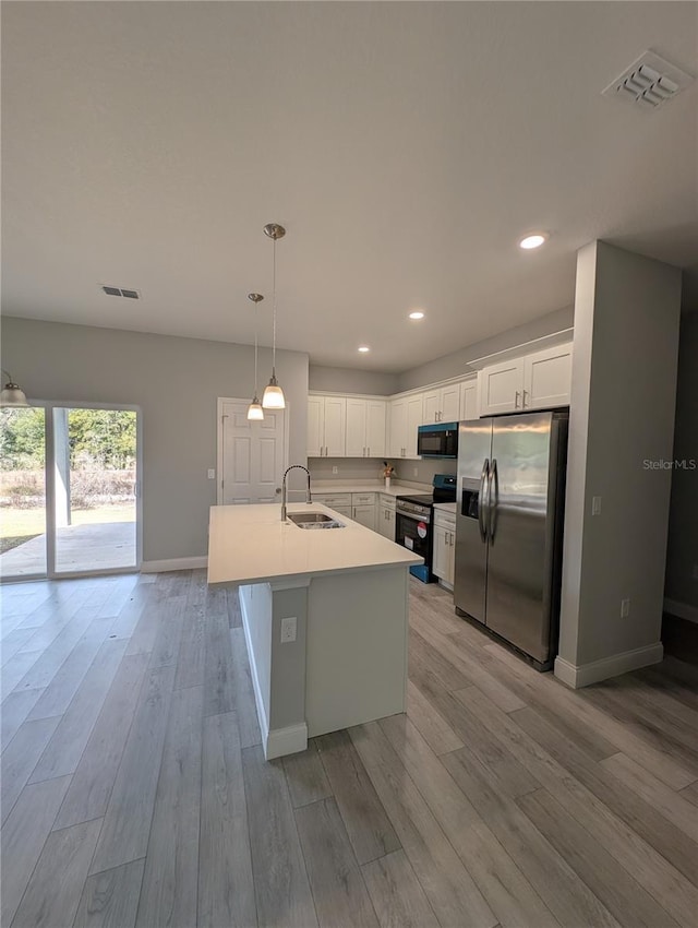 kitchen with stainless steel appliances, white cabinetry, hanging light fixtures, and sink