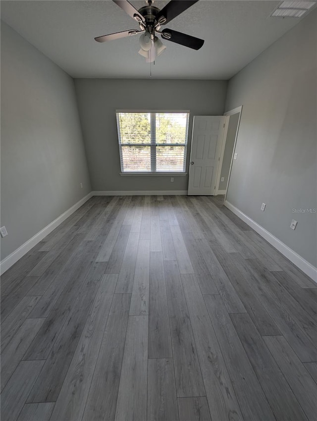 empty room with ceiling fan and light hardwood / wood-style flooring