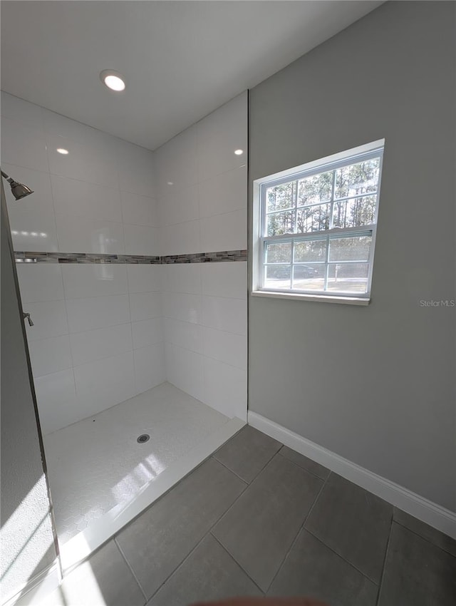 bathroom with tile patterned flooring and tiled shower