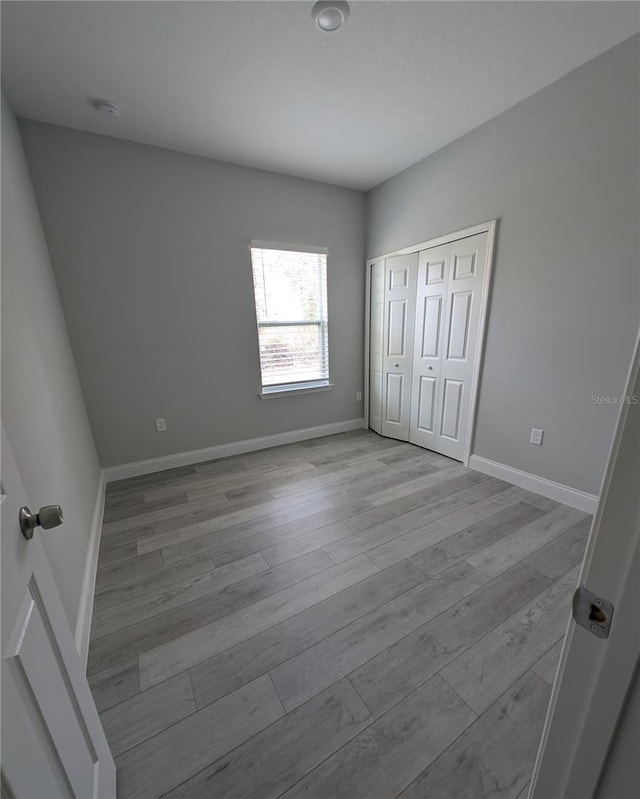 unfurnished bedroom with a closet and light hardwood / wood-style flooring