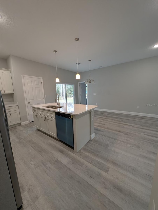 kitchen with appliances with stainless steel finishes, sink, decorative light fixtures, and an island with sink