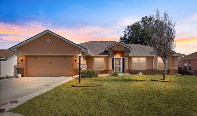 view of front of property with a garage and a lawn