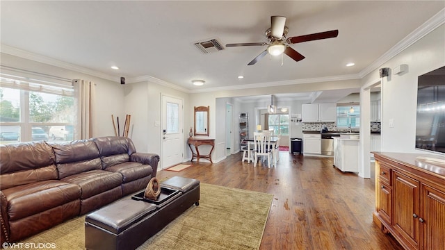 living room with ceiling fan, ornamental molding, sink, and hardwood / wood-style floors