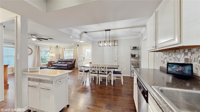 kitchen featuring white cabinetry, crown molding, dark hardwood / wood-style flooring, ceiling fan with notable chandelier, and decorative backsplash