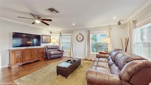 living area featuring baseboards, visible vents, crown molding, light wood-type flooring, and recessed lighting