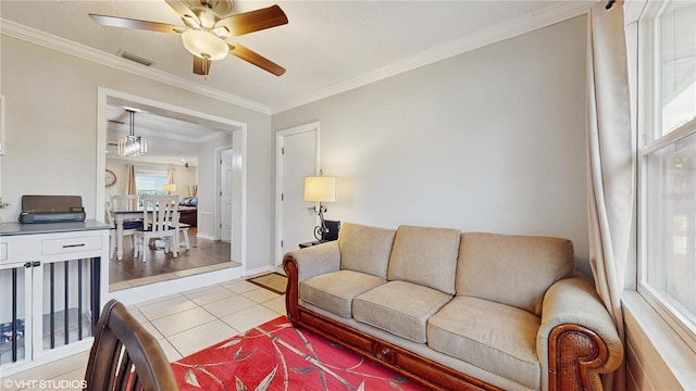 living area featuring light tile patterned floors, ornamental molding, visible vents, and a ceiling fan