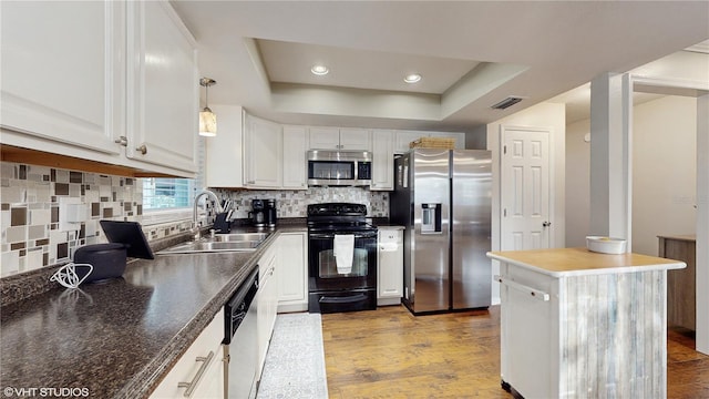 kitchen with visible vents, a sink, light wood-style floors, appliances with stainless steel finishes, and a raised ceiling