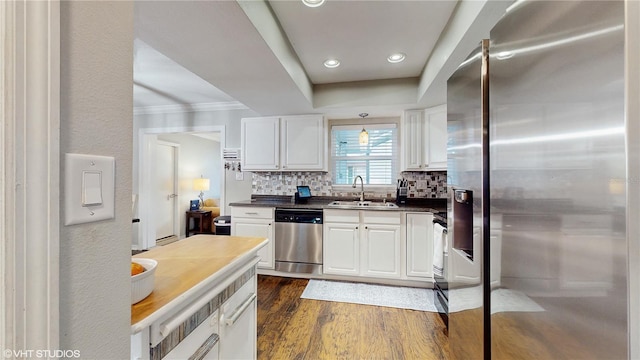 kitchen with a sink, stainless steel appliances, white cabinets, and dark wood-style flooring